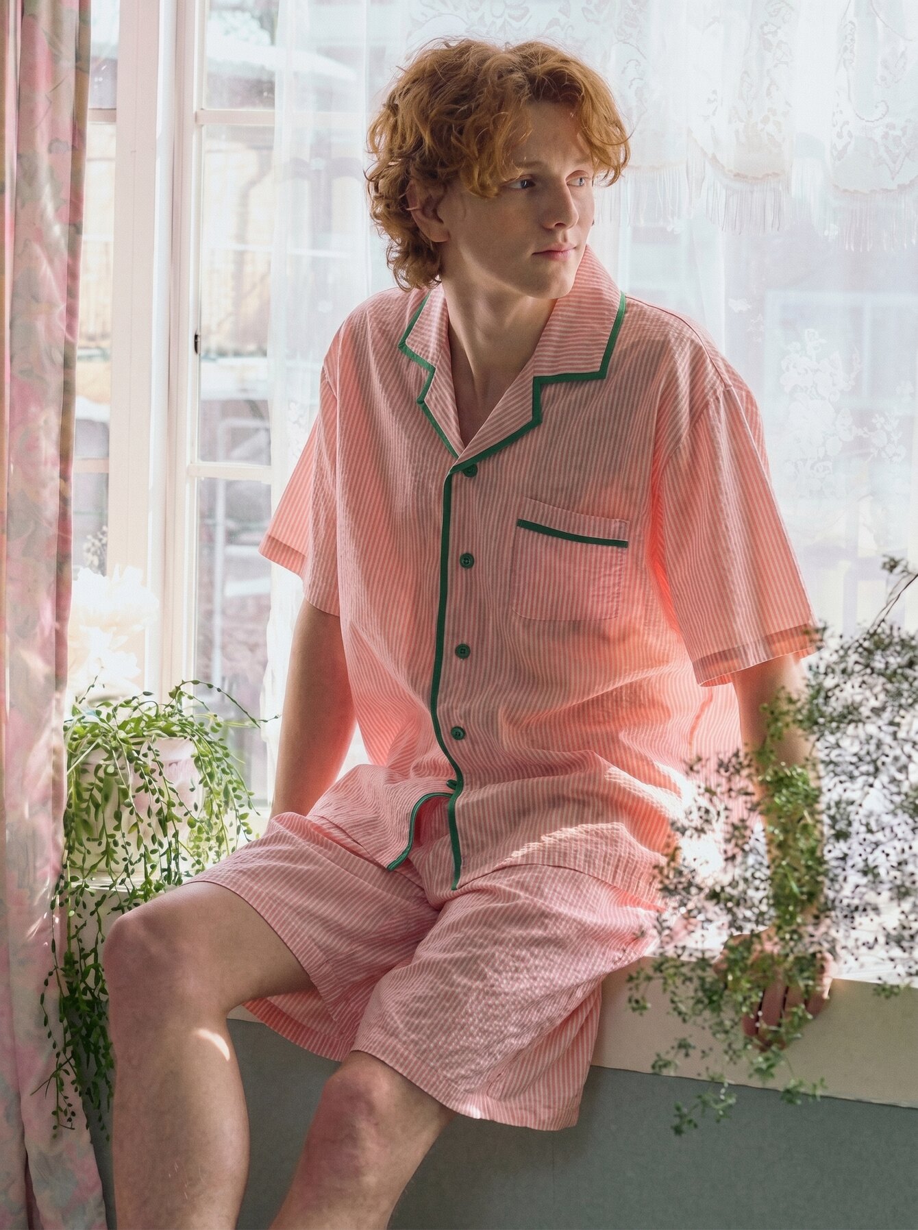 Man in soft pink Cloud 9 pajamas by a window
